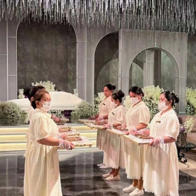 فريق خدمة نسائي في قاعة زفاف يقدم الضيافة أمام المسرح
كنموذج لتنظيم طاقم القاعة والإشراف على حفل الزواج